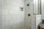 standing tile shower in full bathroom